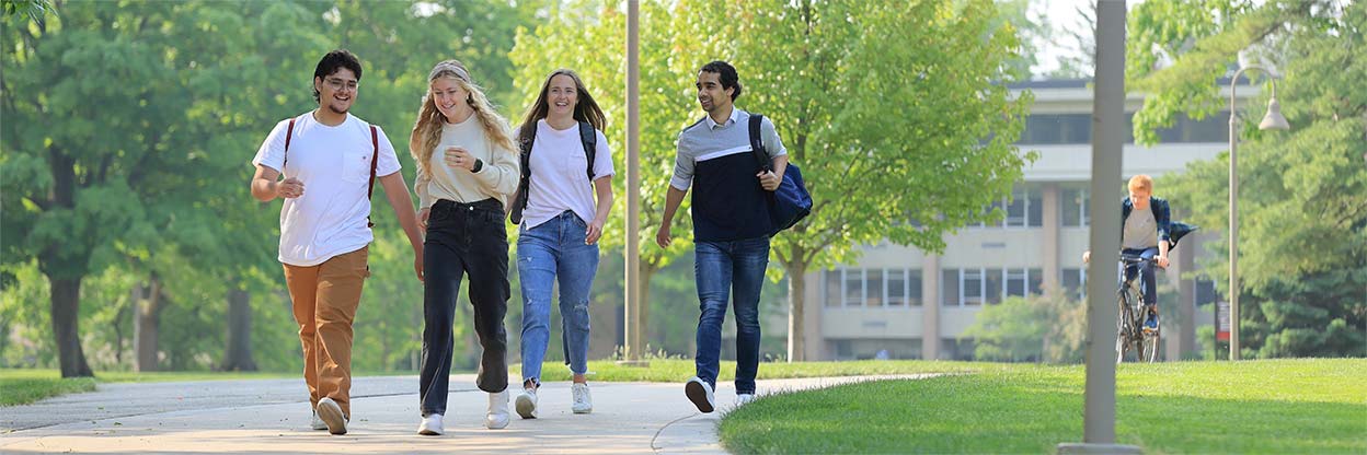 Four students walking across campus on their way to summer classes.