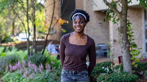 Calvin University student standing outside on campus and smiling